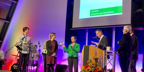 Stephanie Feder und Birgit Mock stehen auf der Bühne mit Matthias Sellmann und Eva Jung vom zap-Innovationspreis.