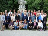 33 Frauen und ein Mann stehen und hocken vor einem Brunnen im Schloss Fürstenried in München.