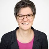 Stephanie Feder mit kurzen braungrauen Haaren und brauner Brille, lächelt in die Kamera.